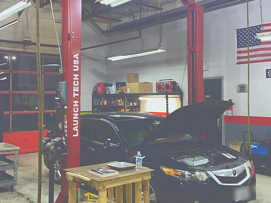 A car up on one of our lifts with the hood open, part way through a job.